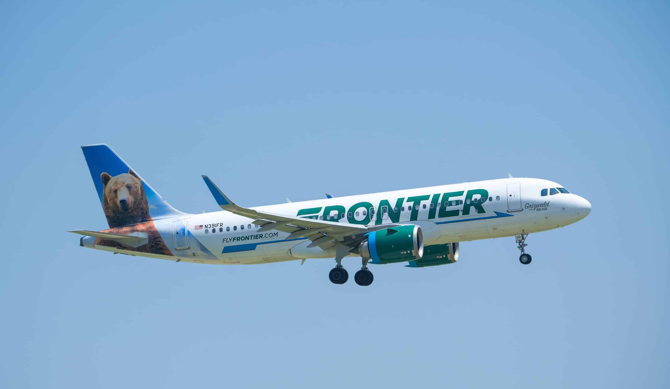 A Frontier airline plane flying in the sky