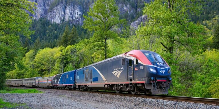 An Amtrak train going running along the tracks in the countryside