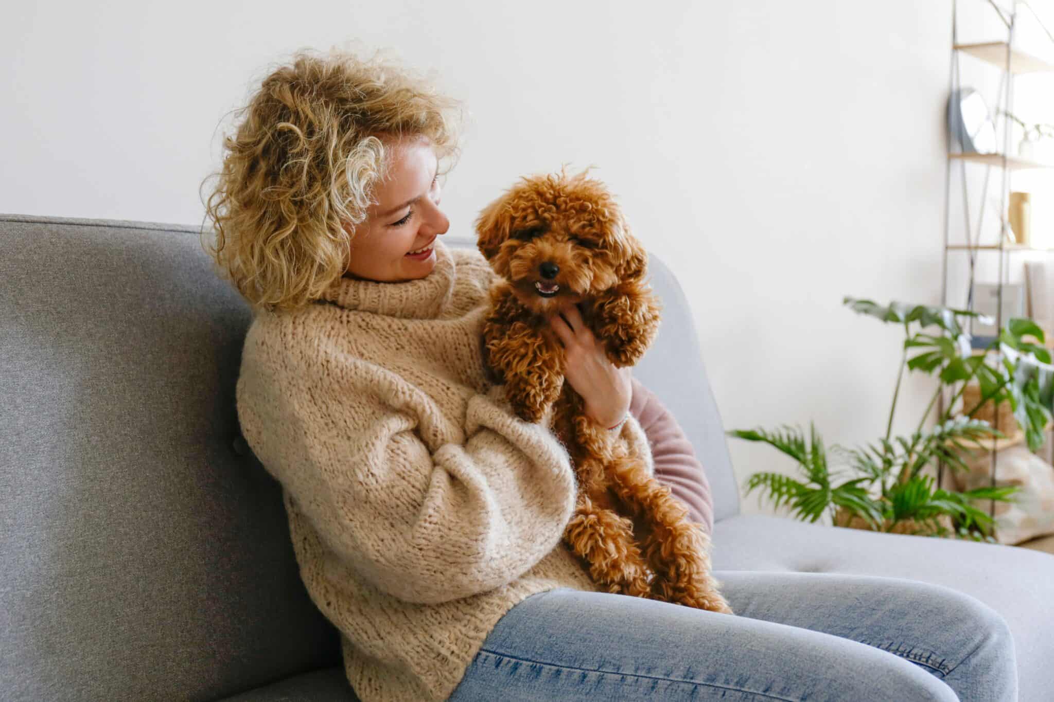 How to Get an Emotional Support Animal in Fort Lauderdale A woman cuddling a dog while sitting on a couch.
