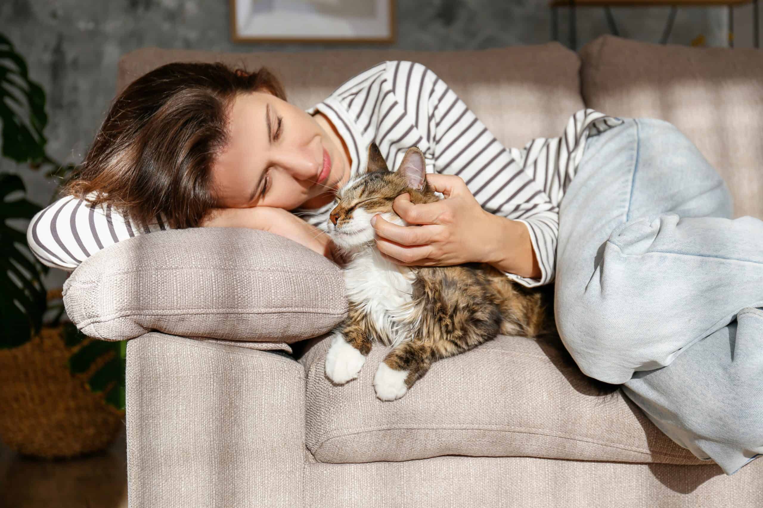 Types of Emotional Support Animals. A woman cuddling with her cat on the couch.
